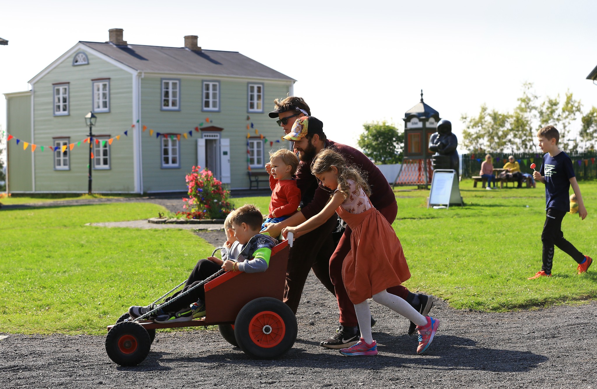 Gestir leika sér með kassabíl fyrir framan Suðurgötu, eitt af safnhúsum Árbæjarsafns.